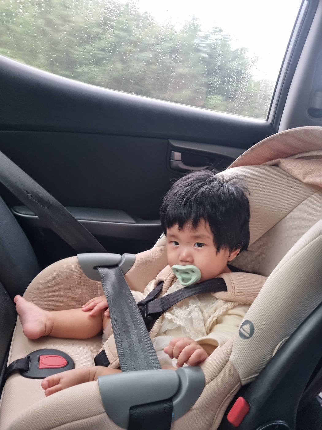 카시트에 앉아 창밖을 보는 사빈이